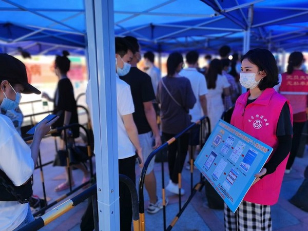 街道妇联党员干部在核酸检测现场协助操作指引.jpg