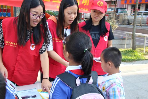 党员志愿者在耐心的向小学生解释如何合理的预防灾难发生